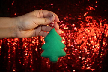Wall Mural - beautiful green Christmas tree is lying on your hand on a shiny background