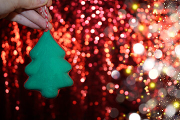 Wall Mural - beautiful green Christmas tree is lying on your hand on a shiny background