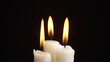 Photo of the burning a three candles on black background