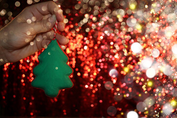 Wall Mural - beautiful green Christmas tree is lying on your hand on a shiny background