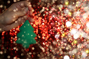 Wall Mural - beautiful green Christmas tree is lying on your hand on a shiny background