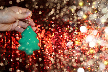 Wall Mural - beautiful green Christmas tree is lying on your hand on a shiny background