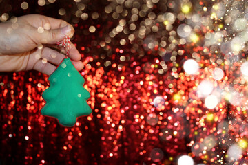 Wall Mural - beautiful green Christmas tree is lying on your hand on a shiny background