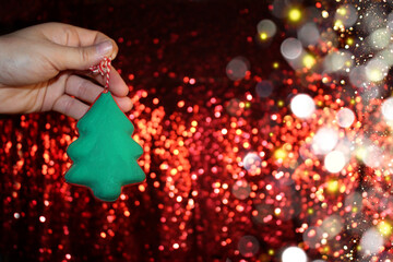 Wall Mural - beautiful green Christmas tree is lying on your hand on a shiny background