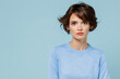 © ViDi Studio - Young serious calm happy caucasian european attractive cute woman 20s in casual sweater looking camera isolated on plain pastel light blue color background studio portrait. People lifestyle concept