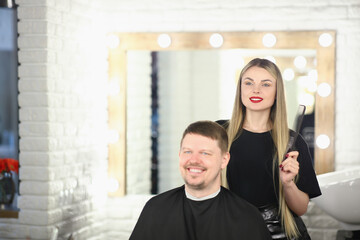 Wall Mural - Professional stylist holding hairbrush for male haircut in beauty studio