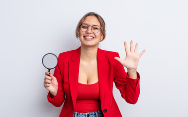 Wall Mural - hispanic pretty woman smiling and looking friendly, showing number five. magnifying glass concept