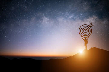 Wall Mural - Silhouette of young businessman standing and open both arm watched night sky view, star and milky way alone on top of the mountain. He enjoyed traveling and was successful when he reached the summit.