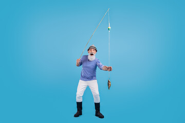 Poster - Full size photo of happy cool positive amazed old man hold hand fishing rod catch isolated on blue color background