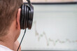 © yaroslav1986 - Close-up of a man with headphones looking at the monitor on red-green graphics, photos from the back