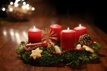 Third Advent - Decorated Advent Wreath From Fir Branches With Red Burning Candles On A Wooden Table In The Time Before Christmas, Festive Bokeh In The Warm Dark Background, Copy Space, Selected Focus