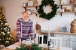 © DariaTrofimova - Mature woman in New Year's sweater setting  festive table.