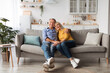 © Prostock-studio - Happy Mature Couple Embracing Posing Sitting On Couch At Home