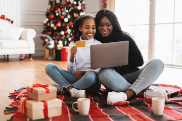 Wall Mural - Xmas Shopping. Smiling black family using pc showing credit card