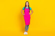 © deagreez - Photo of cheerful positive charming maid lady posing wear pink apron sneakers isolated yellow color background