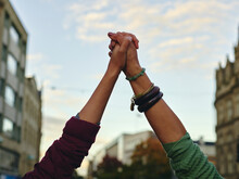 Two Women Holding Hands Up In Air