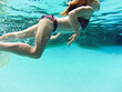 © Austockphoto - Young girl swimming underwater at a pool