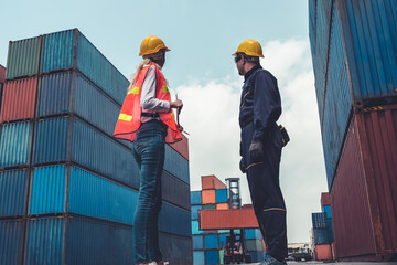 Wall Mural - Industrial worker works with co-worker at overseas shipping container yard . Logistics supply chain management and international goods export concept .