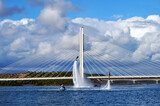 Fototapeta Na sufit - Flyboarding while using a jet ski in Portimao harbour with Portimao bridge in the background.