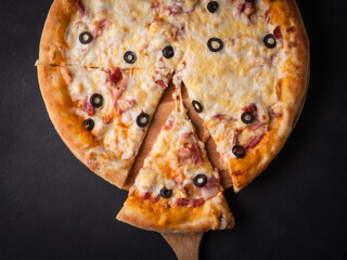 Wall Mural - Home pizza with sausage, cheese, olive, pepper, Spices on black background. Supreme Hot Pizza