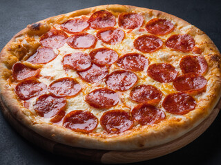 Wall Mural - Pepperoni pizza with sausage on a dark background.