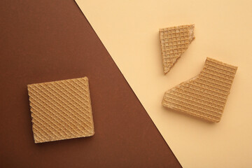 Wall Mural - Square chocolate wafer biscuits on brown colorful background.