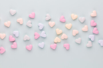 Poster - Composition with candy hearts on pastel blue background.