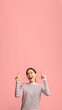 © Prostock-studio - Cheerful Young Korean Female Pointing Up At Copy Space Above Her Head