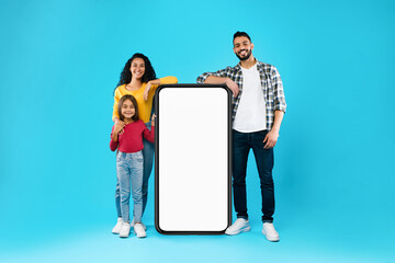 Wall Mural - Arab Family Standing Near Huge Phone Screen On Blue Background