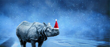 Rhinoceros In Santa Claus Hat Over Snowy Background, Merry Christmas Concept, Panoramic Image