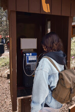 Young Girl Using Old Fashioned Telephone Booth To Make Phone Call