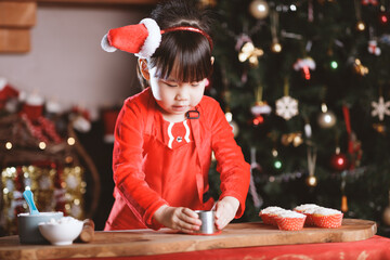 Wall Mural - young girl making Santa cupcake for Christmas party at home