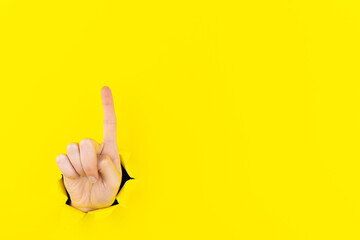 Woman hand showing number gesture isolated over pastel yellow background in studio. Copy space for advertisement. With place for text or image, promotional content.