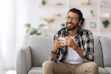 Handsome arab man with tea mug looking at copy space