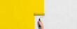 壁にローラーで黄色いペンキを塗る手の背景テクスチャー。