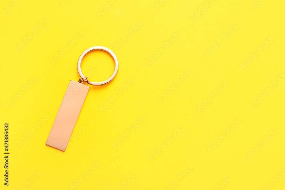 Stylish keychain on yellow background
