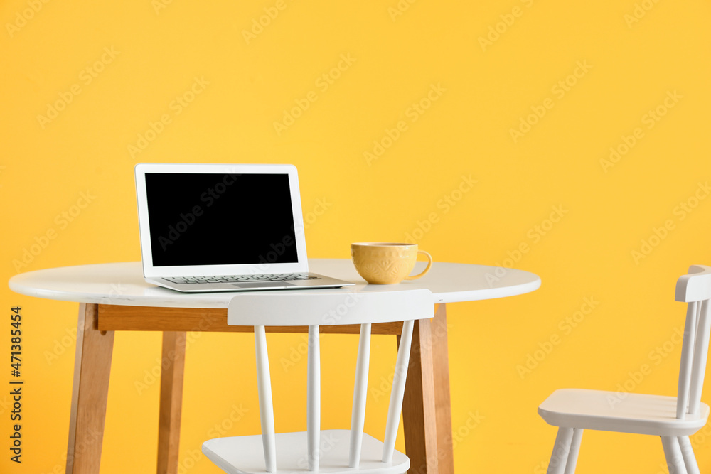Modern workplace near yellow wall
