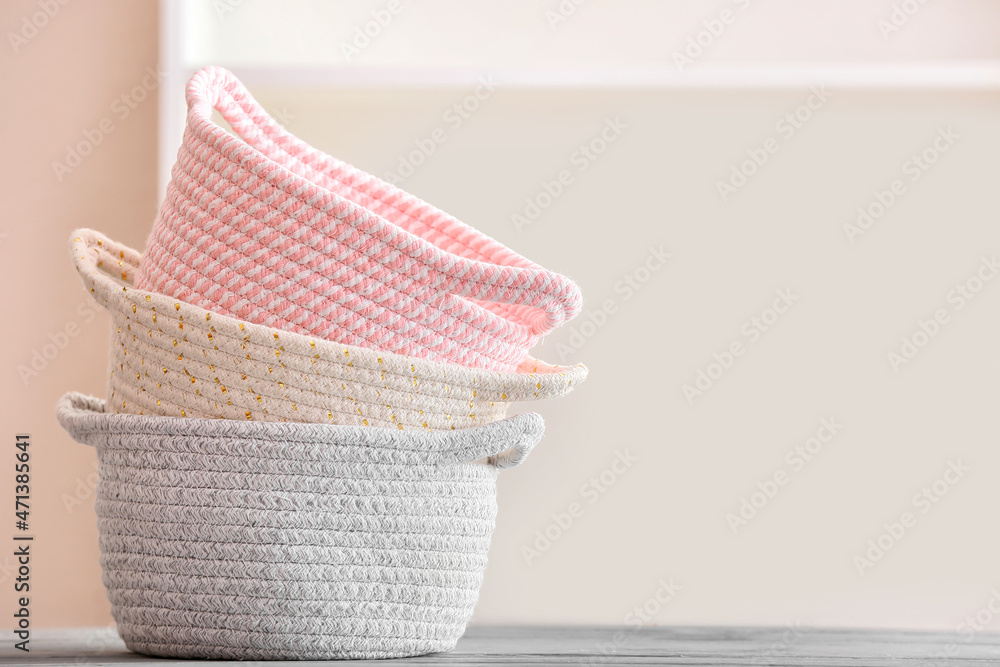 Stylish knitted baskets on table, closeup