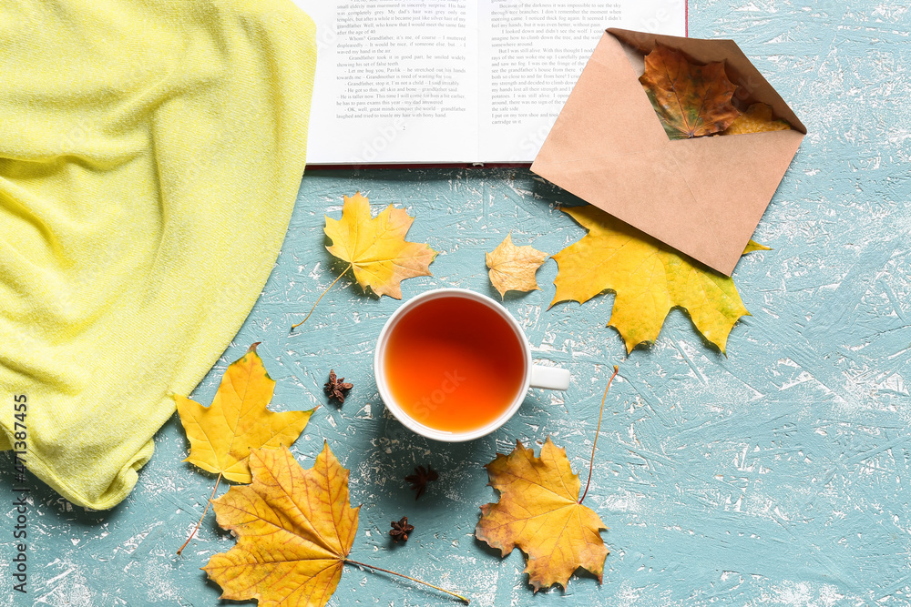Composition with cup of tea, envelope and autumn leaves on color background