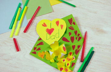 Wall Mural - Greeting card for on Father's Day heart with lettering. Envelope  crafts and flower from colorful paper. Handmade. DIY concept. little girl prepared a surprise for dad