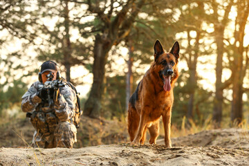 Wall Mural - Soldier with military working dog during combat operation outdoors