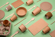 Set of different eco-friendly tableware and kraft paper food packaging on green background. Street food paper packaging - cups, plates, straws, containers, paper bags and wooden cutlery. Mockup