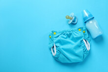 Concept Of Baby Clothes With Reusable Diapers On Blue Background