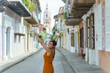 Front view of cheerful woman isolated on Cartagena de Indias street. Horizontal view of tourist traveler woman sightseeing in Colombia. People and travel concept.