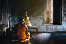 A Monk Is Worshiping And Meditating In Front Of The Golden Buddha As Part Of Buddhist Activities.