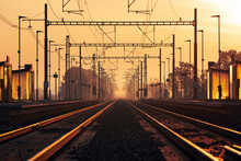 Railway At Golden Sunrise. Diminishing Perspective Of Two Empty Railroad Tracks In Station.