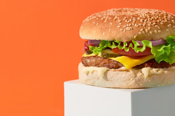 Wall Mural - Close up fresh tasty burger on orange background. Cheeseburger with beef, tomato, pickles, lettuce and onion