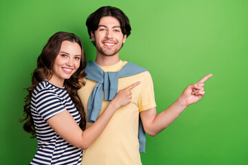 Poster - Photo of young couple happy positive smile indicate fingers empty space ad promo isolated over green color background