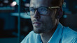 © Gorodenkoff - At Night Portrait of Handsome Startup Digital Entrepreneur Working on Computer, Line of Code Reflecting in Glasses. Developer Working on Innovative e-Commerce App using AI Algorithm Big Data. Blue