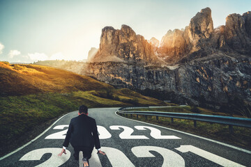 The 2022 New Year journey and future vision concept . Businessman traveling on highway road leading forward to happy new year celebration in beginning of 2021 for fresh and successful start .